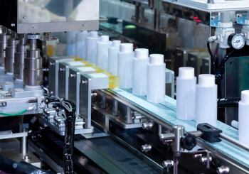 an assembly line of a cosmetic product in an opaque bottle travelling down the line