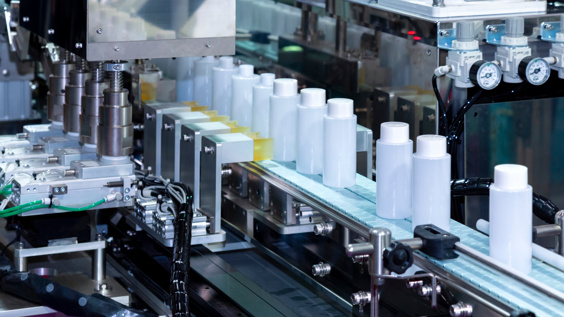 an assembly line of a cosmetic product in an opaque bottle travelling down the line